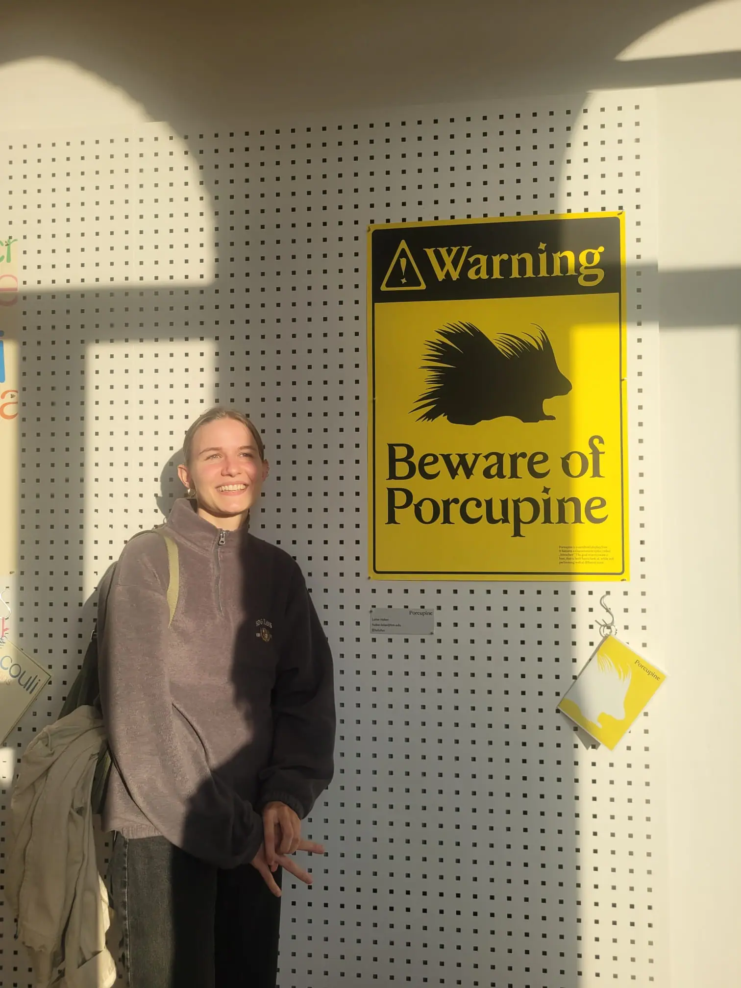 A picture of Luise standing next to a poster.